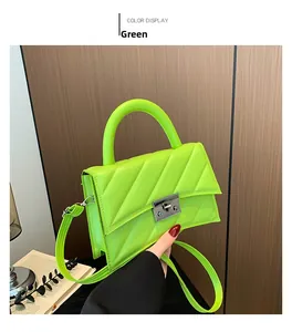 Détail du sac bandoulière matelassé vert avec fermoir argenté et surface texturée