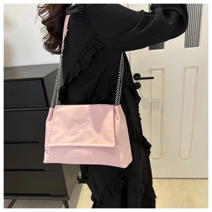 Detailed view of pink butterfly embroidery and metallic chain on the stylish shoulder bag