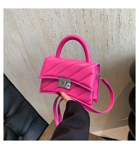 Détail du sac bandoulière fuchsia avec surpiqûres en V et fermoir métallique chic