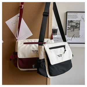 Détails des sacs messagers en toile bicolore avec rabat et poches zippées frontales
