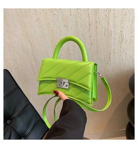 Détail du mini sac en cuir matelassé vert fluo avec boucle argentée et poignée