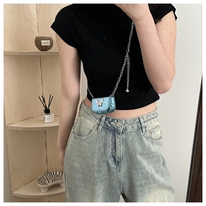 Detail of electric blue metallic mini crossbody bag with silver butterfly and chain strap