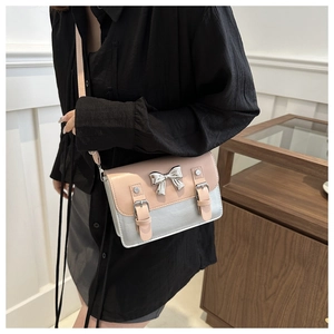 Détail du sac bandoulière rose avec nœud argenté et lanières à boucles élégantes