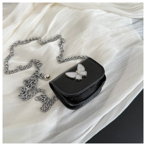 Close-up of black mini crossbody bag with a shell-like butterfly clasp and silver chain