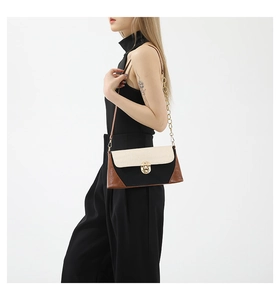 Detail of tricolor baguette bag with crocodile texture flap and gold metal clasp