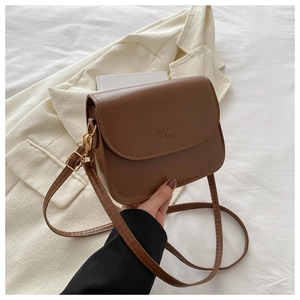 Close-up of brown PU leather crossbody bag with embossed logo and golden metal buckle