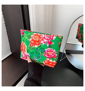 Dettaglio della pochette in nylon con motivo floreale e chiusura a zip dorata