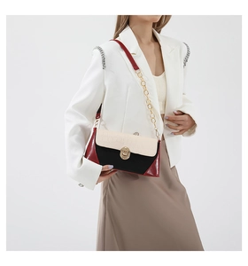 Detail of tricolor baguette bag featuring crocodile texture and gold swivel lock
