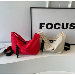 Side-by-side view of red and beige nylon dumpling bags with adjustable straps