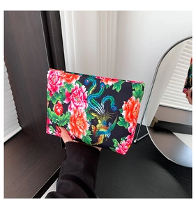 Dettaglio pochette in nylon con fenice colorata e motivo floreale di peonia