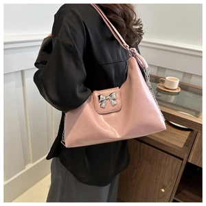 Detail of pink hobo bag with silver bow ornament and metallic chain strap