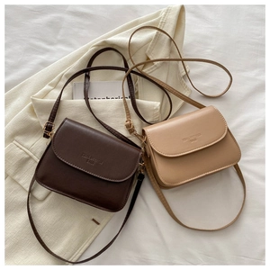 Detail of minimalist crossbody square bags in dark chocolate and warm beige faux leather