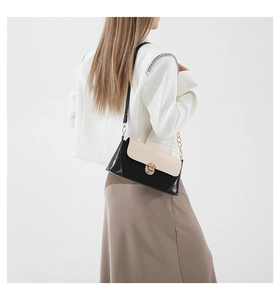 Detail of color-block baguette bag featuring crocodile texture and gold metal twist lock