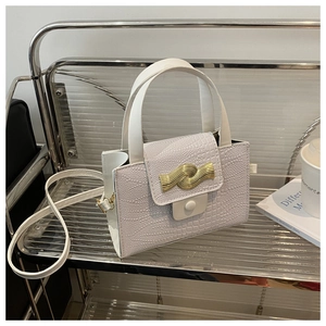 Gros plan sur la texture crocodile blanc avec boucle dorée élégante du sac à bandoulière