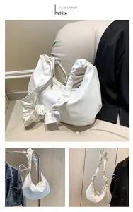 Détail de la bandoulière plissée blanche et de la forme en croissant du sac hobo