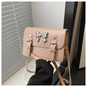 Détail du nœud en métal argenté et des boucles sur un petit sac bandoulière rose