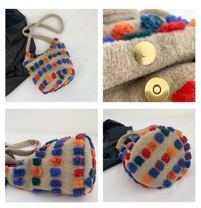 Detail of colorful pom-poms and gold magnetic clasp on a knitted bucket bag