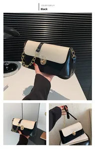 Detail of black and white crocodile texture shoulder bag with gold chain and metal lock