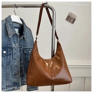 Close-up of brown PU leather hobo bag with vertical stitching on metal hanger