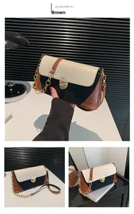 Detail of tricolor baguette bag with crocodile texture flap and gold chain strap