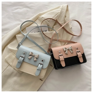Détail de sacs bandoulière vintage avec boucle nœud en métal et design bicolore