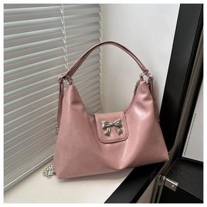Macro detail of silver bow metallic buckle on pink PU leather hobo shoulder bag