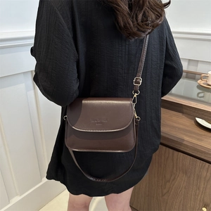 Classic dark brown PU leather crossbody square bag worn by a model in a minimalist setting