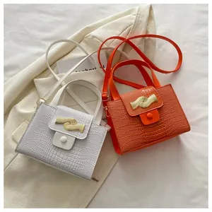 Détail de sacs bandoulière en crocodile avec boucles métalliques dorées en blanc et orange