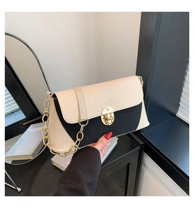 Detail of two-tone baguette bag with white croc-embossed leather and gold chain strap