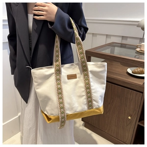 Détail du grand sac cabas en toile avec bloc de couleur jaune et bandoulière géométrique