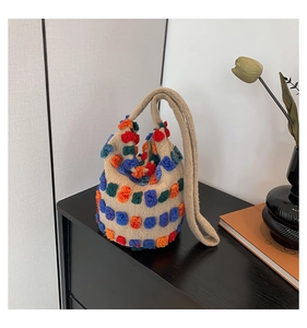 Detail showing the colorful tufted cubes and woven texture of the bucket bag