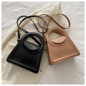 Chic trapezoid handbags in black and beige with round handles and gold hardware details