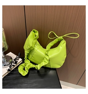 Détail du sac à bandoulière vert fluo avec poignée à volants et design noué