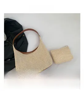 Detail of woven straw hobo bag set with brown leather trim and matching zip pouch