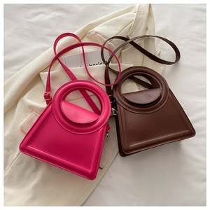 Chic rose red and brown trapezoid handbags with circular cutout handles on beige blazer