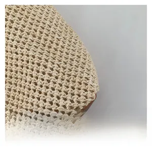 Detail shot of beige woven fabric with brown leather edge on a summer tote bag