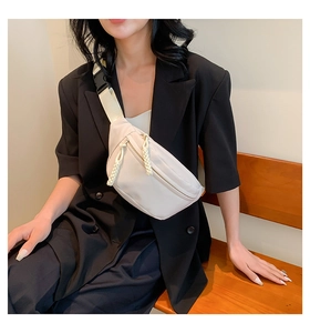 Detail of waterproof nylon crossbody bag with woven zipper pull and plastic buckle