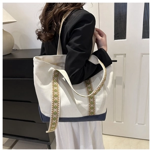Détail du sac cabas en toile avec bretelles tissées ethniques et base en patchwork bleu marine