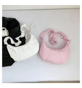 Détail de sacs à bandoulière blanc et rose avec un design de sangle nuage minimaliste