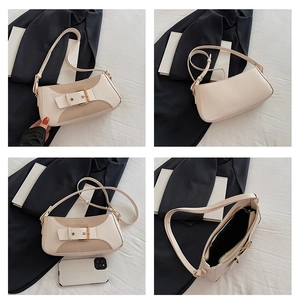 Detail view of contrast color shoulder bag with metal buckle and interior zipper pocket