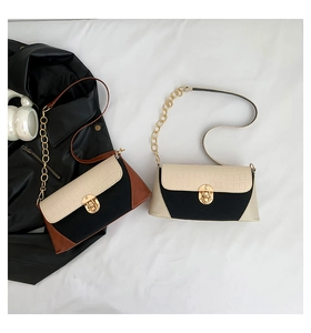 Close-up of contrast patchwork bags with crocodile texture and gold hardware details