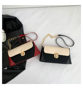 Close-up of crocodile pattern bags with gold hardware and chain straps in red and black