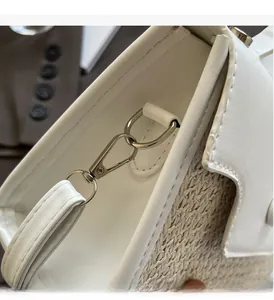 Detail of woven straw and white leather patchwork with polished silver hardware