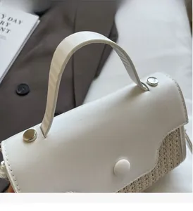 Detail of white leather and woven straw texture with a round decorative buckle on the bag