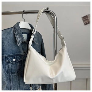 Detail of adjustable strap and smooth white leather finish on minimalist hobo bag