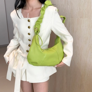 Sac hobo vert citron plissé porté par un mannequin en blazer blanc chic