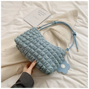 Detail of light blue pleated shoulder bag featuring bubble texture and flower pendant