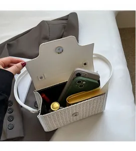 Interior view of the woven crossbody bag showing space for phones, wallet and lipstick