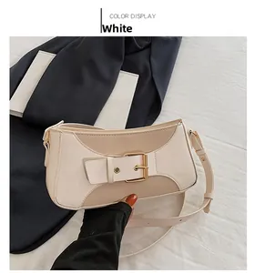 Close-up of cream underarm bag featuring a metallic gold buckle on smooth faux leather