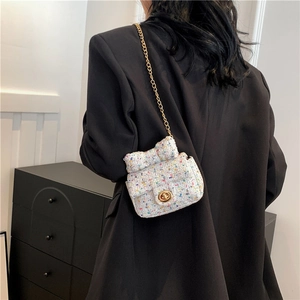 Crossbody tweed mini bag with bow detail and gold chain strap on a model
